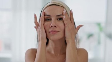 Banyo portresinde cilt hastalığından hoşlanan tatmin olmuş bir bayan. Duş görüntüsünden sonra güzel kız yumuşak yüze dokunuyor. Gülümseyen kadın kamerayı eve yakın çekim yapıyor. Yüksek özsaygı ve refah kavramı