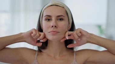 Kapalı alan pov görüntüsünde tatmin olmuş model yüz masajı. Yakından gülümseyen kadın mükemmel sağlıklı cilt durumu için heykel yapma prosedürü uyguluyor. Günlük cilt bakımı rutin portresi.