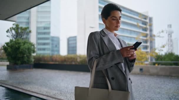 公司经理在市中心输入消息 在当代金融区忙着给手机发短信的女人 时尚的女商人在网上回复电子邮件查询新闻 多愁善感的Ceo使用智能手机 — 图库视频影像