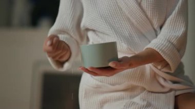 Kadın el banyosu tuzu suya yakın çekim. Kimliği belirsiz bir bayan sıcak bir yerde köpük küveti hazırlıyor. Tanımlanamayan dinlenmiş model, akşam atmosferinin keyfini çıkarıyor.