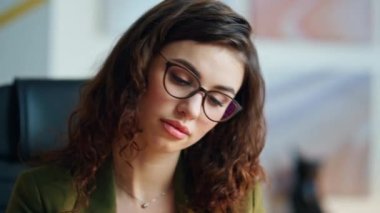 Kendine güveni tam bir iş kadını ofis masasında iş belgelerini yakın tutuyor. Kapalı alanda tasarım örneklerine bakan çekici kız çalışana odaklanmış. Kadın tasarımcı modern işyerinde yeni fikirler üretiyor.