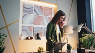 Modern ofiste telefonla iletişim kurmakla meşgul bir kız yöneticisi. Çekici başarılı iş kadını iş belgelerine bakarak telefonla konuşuyor. Kahve fincanı konuşan bir şirket çalışanı..