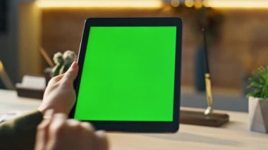 İş yerinde internet sörfü yapmak için krom anahtar tablet kullanan tanınmamış bir iş kadını. Ofiste elinde yeşil ekran bilgisayar tutan kadın elleri dokunmatik ekrana dokunuyor. Yönetici model aygıtı üzerinde çalışıyor
