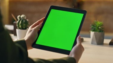 Bilinmeyen yönetici çalışma masasında oturmuş krom anahtar tabletini izliyor. Modern ofiste kadının elleri yeşil ekranlı bilgisayarı tutuyor. İş kadını çevrimiçi eğitim amaçlı webinar 'ı model cihazında arıyor.