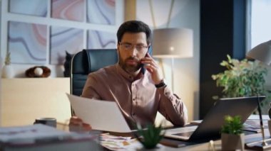 Kendine güvenen ciddi bir işadamı ofis masasından iş evraklarını arıyor. Orta yaşlı, sakallı bir adam, iş projesini telefonla konuşuyor. İşçi iş yerinde akıllı telefondan konuşuyor.