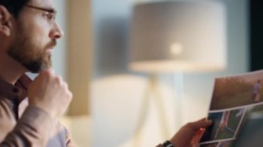 Kurumsal ofiste çalışan yaratıcı direktör kapatıyor. İş yerinde tasarım örneklerine bakan kendine güvenen ciddi bir iş adamının portresi. Orta yaşlı sakallı şirket yöneticisi kağıtlara odaklanmış..