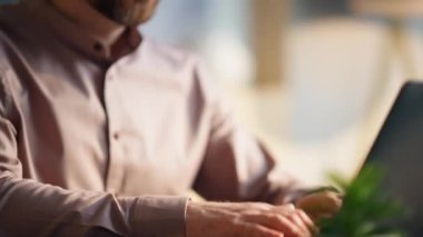 Laptop klavyesinde daktilo yazan adam ev ofisini kapatıyor. Uzaktan kumanda için modern bilgisayarı kullanan çok zeki bir serbest çalışanın portresi. Orta yaşlı sakallı menajer yeni fikirler üretiyor..