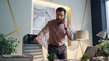 Başarılı bir şirket sahibi cep telefonunu ofis odasından arıyor. Orta yaşlı, sakallı, gülümseyen akıllı telefondan iş belgelerine bakan bir yönetici. Mutlu iş adamı telefon görüşmesi yapar..