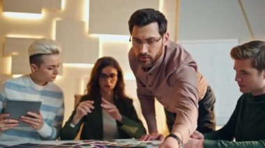 Çeşitli grup çalışanları konferans odasında beyin fırtınası yapıyor. Akıllı yaratıcı ekip ofiste iş stratejisi planlaması yapıyor. Sakallı patron iş projesini meslektaşlarına gösteriyor..