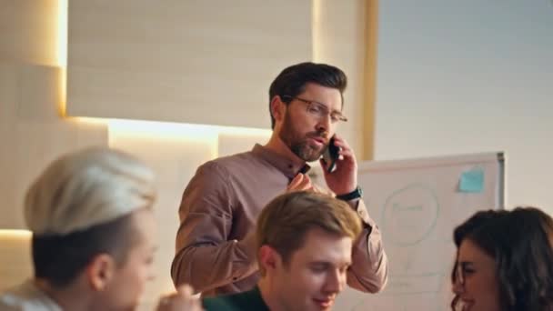 有信心的领队在公司会议上用电话交谈 有胡子的经理要求同事不要说话 在会议室一起工作的年轻商业伙伴 — 图库视频影像