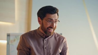 Ofis toplantısında konuşan mutlu sakallı patron iş başarısını kutluyor. Toplantı odasındaki konferans konuşmasında gülümseyen orta yaşlı kendine güvenen yöneticinin portresi. Neşeli konuşmacı işten memnun..