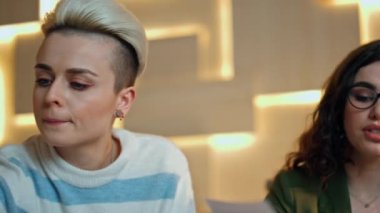 Ofis konferans odasında birlikte çalışan odaklanmış iş ekibi. Kapatın. Genç yaratıcı kadın yöneticiler sakallı patrona kağıtlarını gösteriyorlar. Ortaklar proje açılışını tartışıyor.