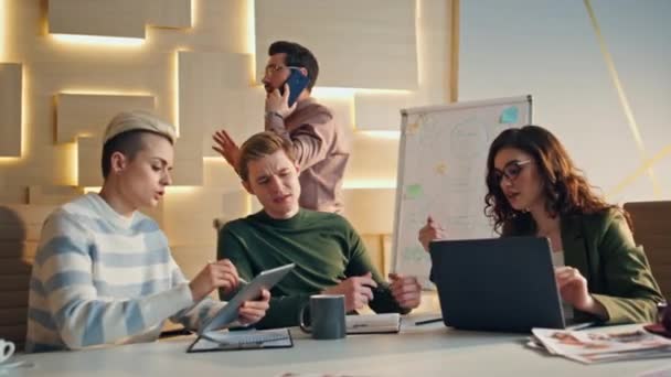 业务团队在办公空间中的互动 在现代会议室工作的富有创造力的团体专业人员 年轻的商人创造商业理念的策略 使用小工具的同事 — 图库视频影像