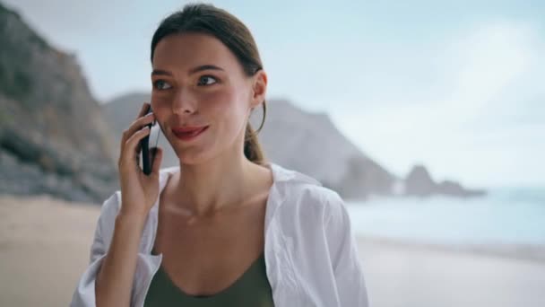 구름낀 해변을 다닌다고 즐거운 여자의 매력적 소녀는 여름휴가 통화를 즐긴다 — 비디오