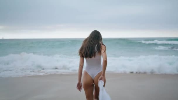 Widok Tyłu Długowłosej Szczupłej Kobiety Chodzącej Burzliwych Falach Oceanu Białych — Wideo stockowe