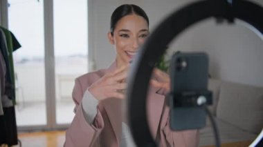 Blogcu kadın odasındaki tripoda akıllı telefonu ayarlıyor. Makyaj hakkında konuşan bir video blogu kaydedicisi. Evde kozmetik hocası olan bir kız. Çevrimiçi öğrenme ve pazarlama kavramı 