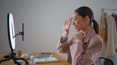 Blogcuları odadaki cep telefonlarına yönlendiren bir yüz tanıyıcı. Yakın plan blog yazarı kadın internet izleyicilerine akıllı telefon yayını yapıyor. Gülümseyen kız evde internetten konuşan video kaydı yapıyor.