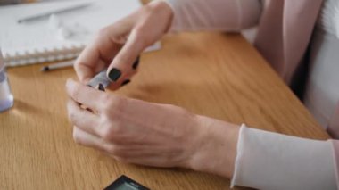 Kadın parmakları kozmetik incelemesi yapıyor. Bilinmeyen makyaj blogcusu içeride güzellik ürünü kayıt blogu döküyor. Kadın Etkilenen Eller ahşap masadan yüz tanıma dersleri yayınlıyor