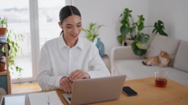 Dost canlısı iş kadını, merkez ofiste bilgisayar görüşmesini selamlıyor. Pozitif öğrenci kız masadaki dizüstü bilgisayara el sallıyor. Neşeli kadın çevrimiçi konuşma öğretmeniyle konuşuyor.