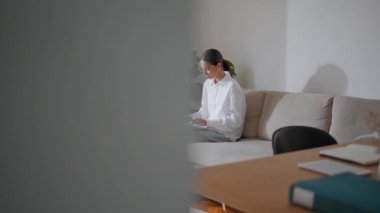 Öğrenci kadın dizüstü bilgisayarda rahat koltukta mesajlaşıyor. Beyaz renklerde klavye oluşturmaya odaklanmış metin yazarı. Akıllı bayan evdeki koltukta bilgisayar kullanarak internetten ders çalışıyor. Uzaktan eğitim