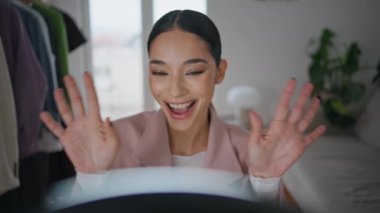 Güzellik blogcusu stüdyoda gülümseyen aboneleri selamlıyor. Akıllı telefon kamerasına makyaj fırçası gösteren duygusal konuşan kadın içeride içerik yaratıyor. Mutlu kız canlı yayın yapıyor.