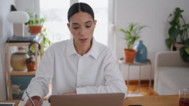 Çalışan kız notları yazıp odadaki bilgisayar görüntülerini izliyor. Kulaklık takan ciddi bir kadın öğretmenle konuşuyor uzaktan yakından öğrenme. Çevrimiçi Webinar dinleyen zeki bayan cevap veriyor