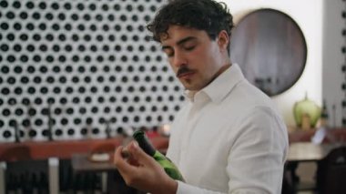 Kıvırcık, çekici bir adam şarap şişesi kokar şarap mahzeninde tek başına dikilir. Kendine güvenen üzüm bağı uzmanı degukasyon için lezzetli bir Merlot açıyor. Şarap yapma konsepti.