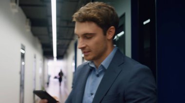 Ofiste gülümseyen profesyonel konuşma telefonu. Mutlu yöneticiler başarıyı kutluyor. Yakışıklı menajer başarılı bir kontratı koridorda tartışır. Neşeli işçi terfi aldı.