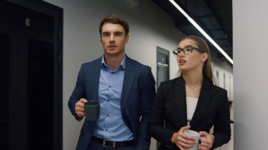 Öğle arasında işçiler ofis koridorunda yürüyorlar. Dost canlısı şirket çalışanları sabah haberleri paylaşmaktan bahsediyorlar. Rahatlamış iş ortakları arkadaşlar kahve içiyorlar. Pazarlama meslektaşları geç saatlere kadar çalışıyor.