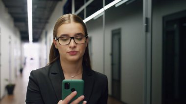 Sanal konferansta portre yöneticisi konuşuyor. Endişeli kadın cam koridorda yürürken kameradan iş ortağını arıyor. Sinirli iş kadını banka asistanı sakin ol. Müşteriyle telefonda konuş.