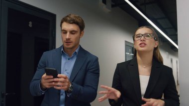 Başarılı yönetim kurulu başkanı talimatları modern salonda veriyor. Müdür not almak için akıllı telefon kullanıyor. Yatırımcıyla iş ortakları planlama toplantısı. Kendine güvenen akıl hocası stajyere projeyi açıklıyor