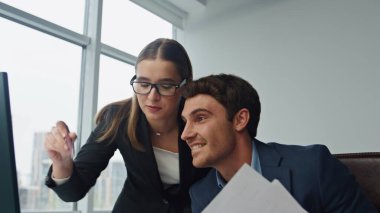 Ofisteki bilgisayarda çalışan mutlu takım, yakın plan. Güzel bir meslektaşla başarılı şirket sonuçlarını kutlayan makaleler atan neşeli bir yönetici. Veri bitirme pazarlama projesini kontrol eden iki çalışan.