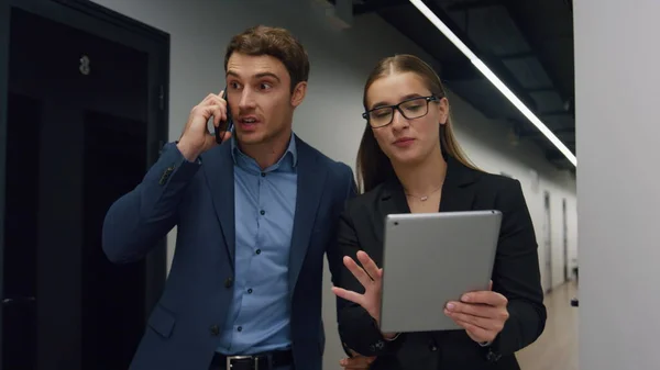 stock image Business partners celebrating good news. Happy managers calling boss executive sharing successful results. Smiling assistant checking online data in tablet walking hallway. Corporate victory concept.