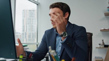 Ofisteki stresli yönetici konuşma bilgisayarı. Sinirli iş adamı, uzaktan görüntülü konuşmada iş arkadaşlarından şikayetçi olduğunu açıklıyor. Başarılı yönetici çözümü iş yerindeki mali sorunları tartışır