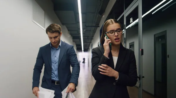 Frustrated business team talking phone. Upset financial manager throw papers thinking project failure bankruptcy. Concerned manager sad businesswoman going corridor explaining meeting results on call