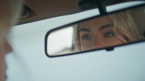 女孩凝视着汽车镜子 近距离欣赏自然美 迷人的金发姑娘坐在车上检查化妆品 自信华丽的女商人 深色眼睛在车镜中倒影 — 图库视频影像