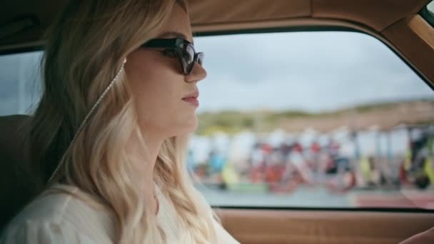 魅力的な女性ドライバーがサングラスをかけて古典的な自動車に乗ってクローズアップ 夏の旅を楽しむ高速道路で運転する自信リラックスした女の子 道路保持車の舵に焦点を当てたスタイリッシュな豪華な女性 — ストック動画