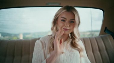 Kadın turist arka koltukta oturuyor. Kameraya bakıp gülümsüyor. Güzel klas kız beyaz elbiseli, retro arabada dinleniyor. Otomobilde poz veren çekici sarışın..