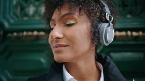 헤드폰을 빈티지 미소짓는 소녀의 현대의 이어폰을 착용하고 매력적 아프리카 미국인 — 비디오