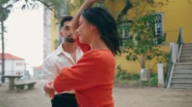 Enerjik mutlu çift şehir caddesinde Latin dansının tadını çıkarıyor. Güzel, şehvetli esmer, sakallı bir adamla ağır çekimde dans ediyor. Tutkulu sanatçılar parkta profesyonelce ilerliyorlar.