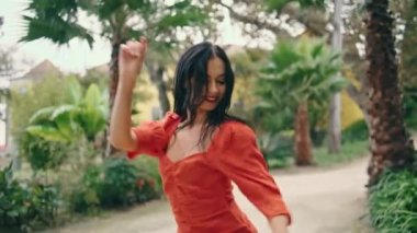 Seksi Latin dansçı kadın baştan çıkarıcı bir şekilde zarif erkek partnere yakından bakıyor. Profesyonel sanatçılar dans gösterisi için yeşil bahçede buluşuyorlar. Tutkulu çift yavaş çekimde tutkudan hoşlanır..