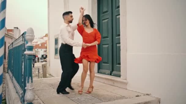 热辣的专业舞蹈演员在美丽的城市街道上表演萨尔萨舞 穿着红色衣服的性感黑发女人和优雅的男伴一起纺纱 激情洋溢的拉蒂诺演奏者慢动作起舞 — 图库视频影像