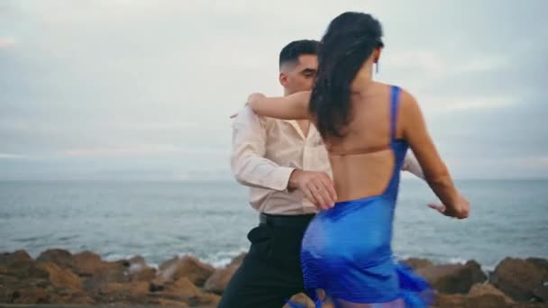 专业的拉蒂诺风格的舞者在多云的海滨表演充满活力的激情舞蹈 美丽的性感女人和优雅的胡子男人慢动作 有爱心的夫妻一起跳舞 — 图库视频影像
