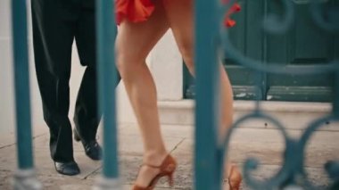 Kapanış dansçılarının bacakları şehir caddesinde Latin Amerikan dansı yapıyor. Bilinmeyen çift enerjik bir şekilde dans ediyor ve yavaş çekimde eğleniyor. Korkulukların arkasında bachata yapan profesyonel şehvetli partnerler.