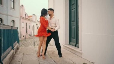 Şehirli dansçılar şehirde Latin Amerika tarzı dans ediyorlar. Kırmızı elbiseli güzel bir kadın zarif bir partnerle dans ederek kalçalarını çeviriyor. Korkuluklarda tutkuyla dolaşan profesyonel bir çift.