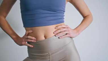 Beyaz Duvar 'da kadın figürlü antrenman vücudu. Spor salonunda el ele tutuşup egzersiz yapan isimsiz atletik kız. Evde tanınmayan bir sabah sporu. Spor rutin konsepti