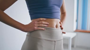 Yakın plan kadın evde bel egzersizi yapıyor. Bilinmeyen atletik bayan karın egzersizi yapıyor sırt kaslarını esnetiyor. Tanınmayan sporcu kadın kalori yakıyor. Sabah sporu rutin kavramı