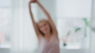 Rahatlamış bir bayan sabahları eve yakın çekim yapıyor. Güzel gülümseyen bir kadının portresi kollarını kaldırarak banyoda yeni bir günün tadını çıkarıyor. Pov view tasasız model uyanma pencere yerinde inceleme yüz