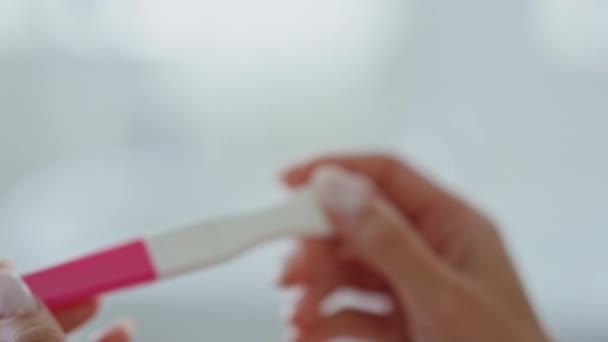 女孩的手在家里等妊娠测试结果 无名氏女士在浴室里看着空塑料试剂盒 女性手指单独在室内握住医疗设备 产妇和母性概念 — 图库视频影像