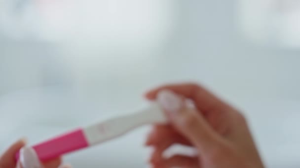 女性手指怀孕测试使室内特写 无法辨认的女士看着消极的一行导致浴室 女孩们在家里检查塑料试剂盒 生育率和保健概念 — 图库视频影像